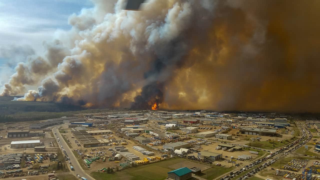 Air shot of forest fire getting close to city